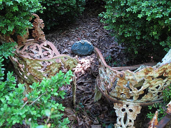 Iron benches tucked away in an enclosed cemetery plot. (May 2012)